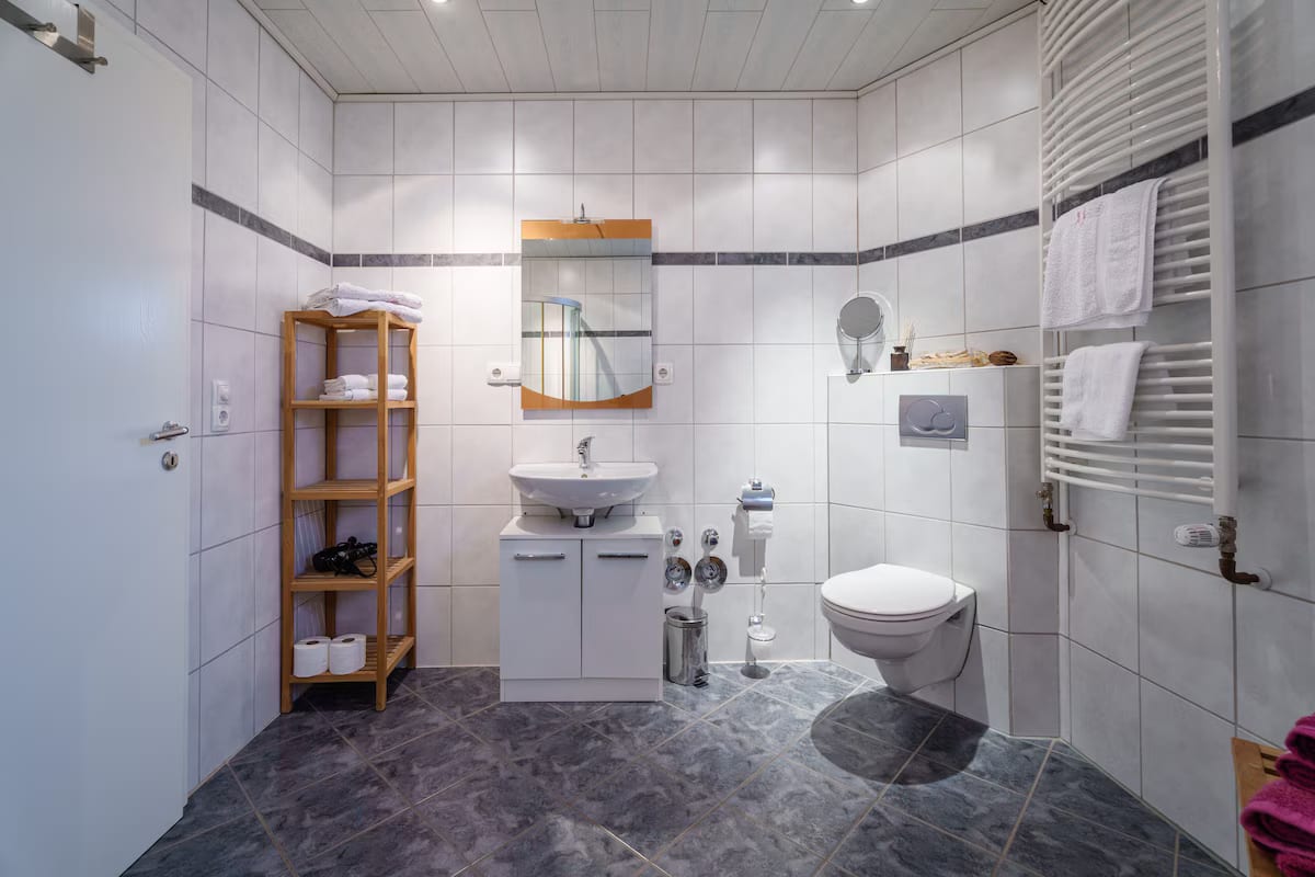 Badezimmer mit Waschtisch, WC und Handtuchheizkörper