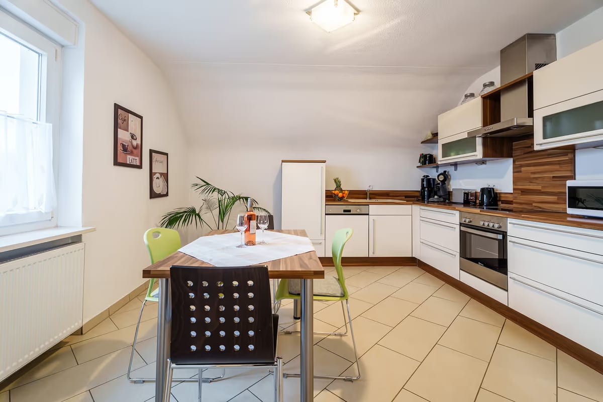 Küchenzeile mit Backofen, Dunstabzug und Esstisch