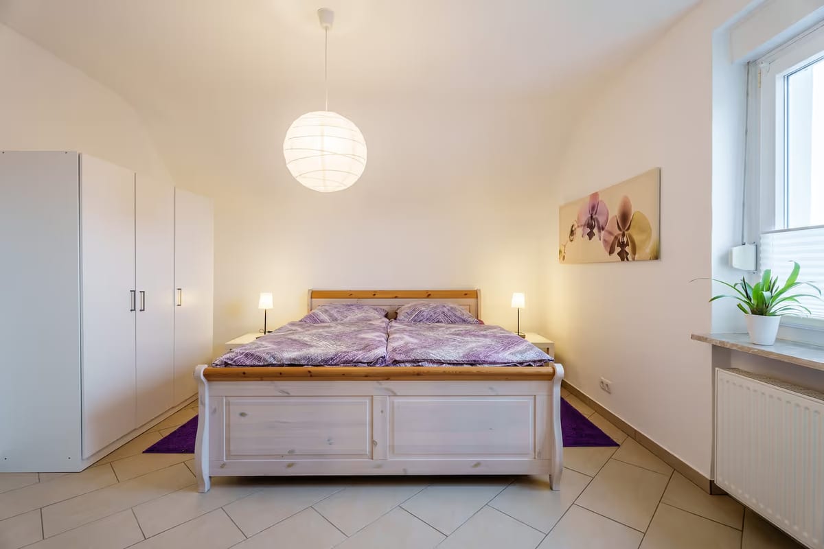 Erstes Schlafzimmer mit Doppelbett, Kleiderschrank und Fenster