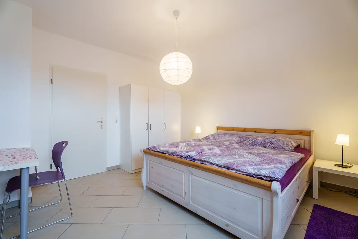 Erstes Schlafzimmer mit Doppelbett, Schreibtisch und Kleiderschrank