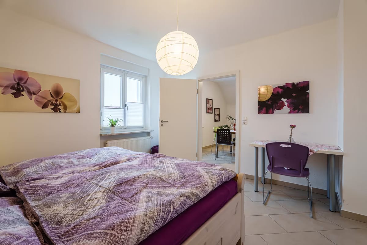 Erstes Schlafzimmer mit Doppelbett, Fenster und Schreibtisch