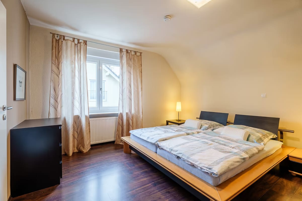 Zweites Schlafzimmer mit Doppelbett, Kommode und Fenster