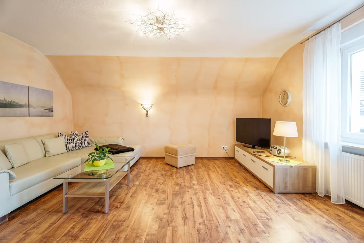 Wohnbereich mit Ecksofa, Hocker und Fernsehmöbel